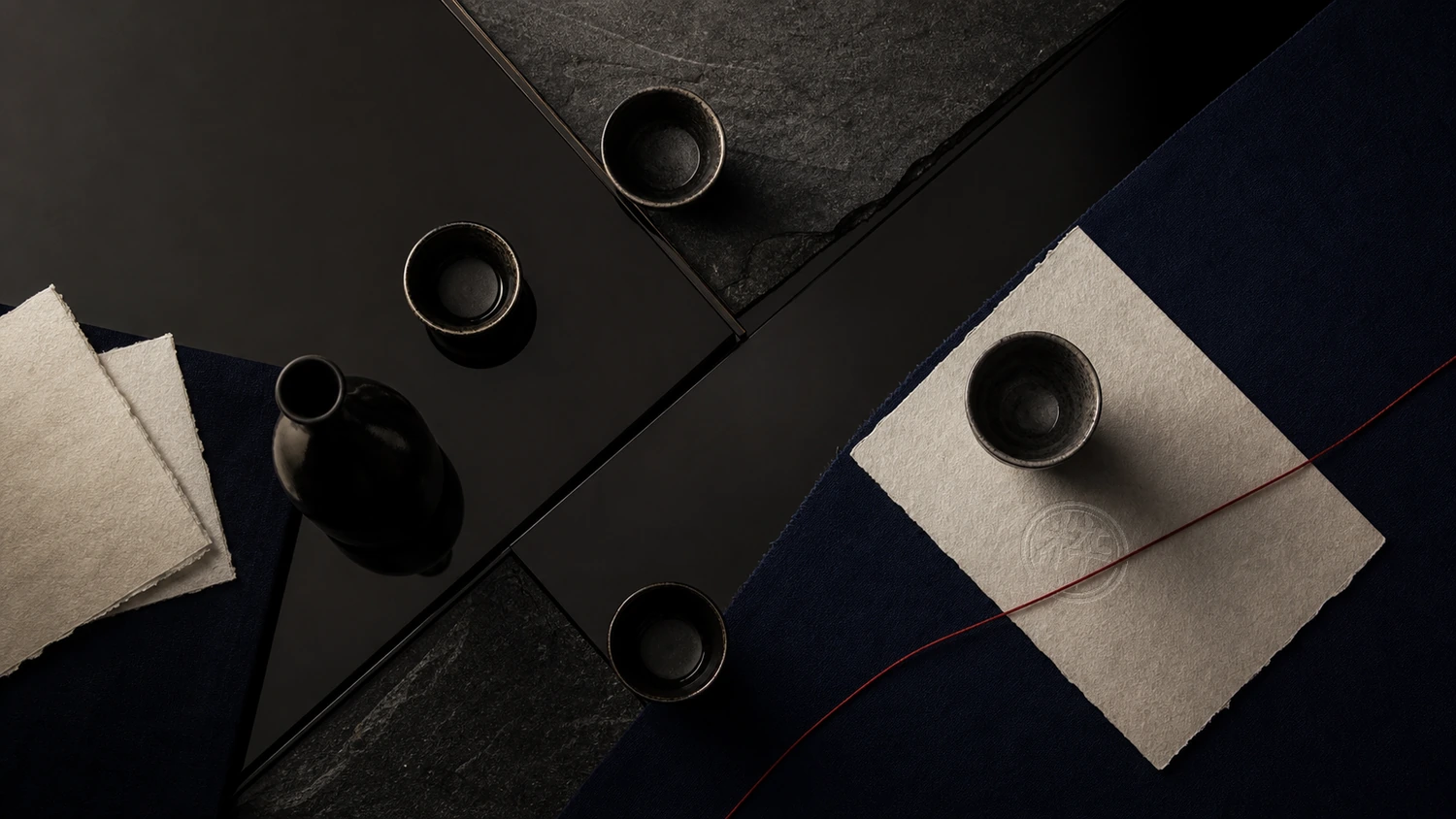 Indigo, washi, lacquer and stone arranged around an IKI mark pressed directly into the paper beneath a red tying cord.