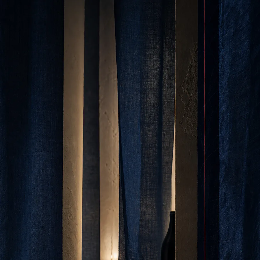 Layers of indigo cloth open towards a warm interior.